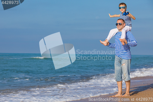 Image of Father and son playing on the beach at the day time. Concept of 