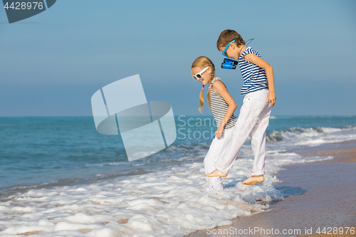 Image of Two happy children playing on the beach at the day time