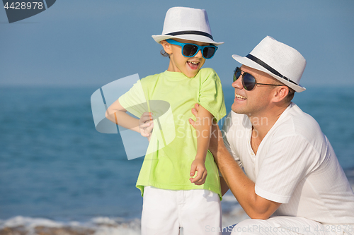 Image of Father and son playing on the beach at the day time. Concept of 