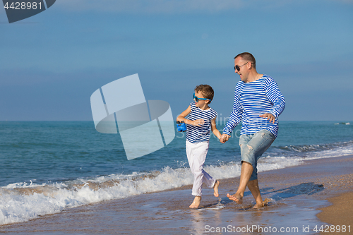 Image of Father and son playing on the beach at the day time. Concept of 