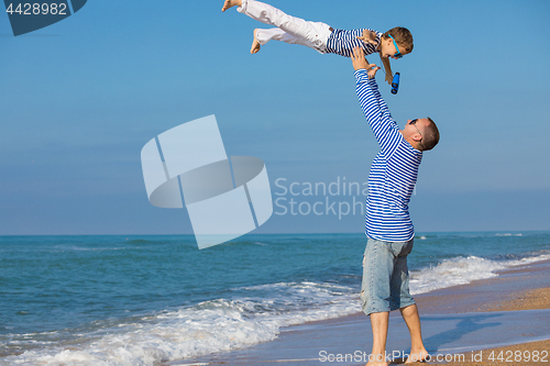 Image of Father and son playing on the beach at the day time. Concept of 