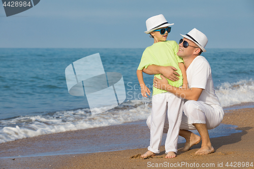 Image of Father and son playing on the beach at the day time. Concept of 