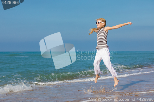 Image of One happy little girl playing on the beach at the day time