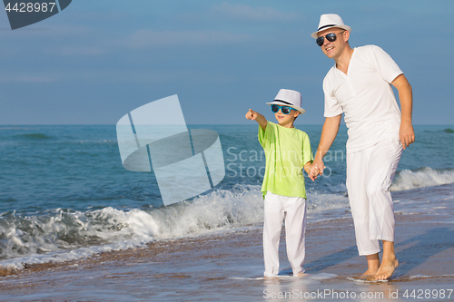 Image of Father and son playing on the beach at the day time. Concept of 