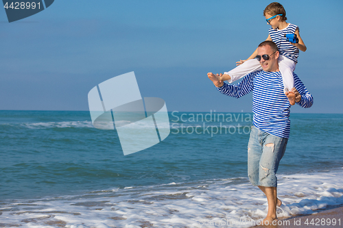 Image of Father and son playing on the beach at the day time. Concept of 