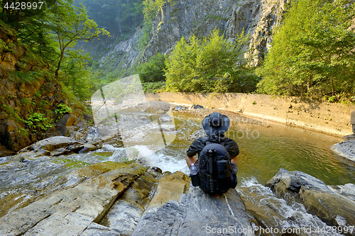 Image of young man with  backpack enjoying  on  mountain