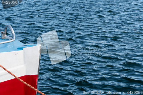 Image of Colorful bow of a boat in rippled water