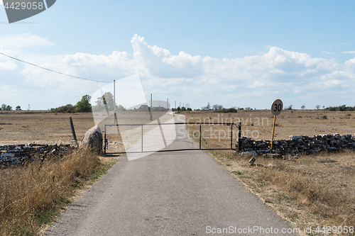 Image of Gate by a country road in a dry grassland