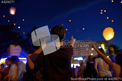 Image of Teens in night watching paper lantern