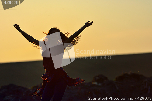 Image of Teen girl jump against beautiful sunset