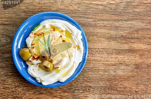 Image of fresh cream cheese with olives and lemon