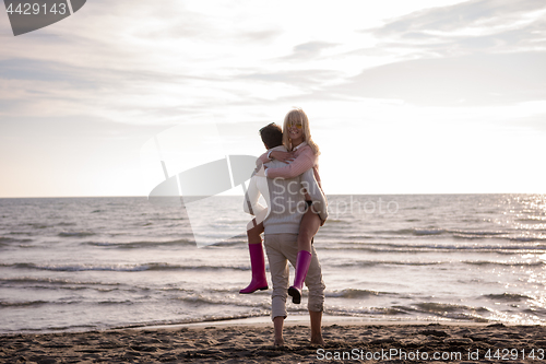 Image of Loving young couple on a beach at autumn sunny day