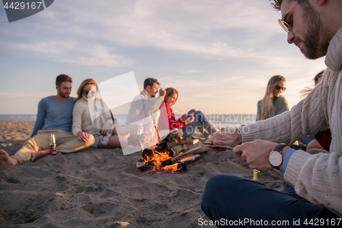 Image of Friends having fun at beach on autumn day