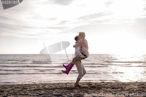 Image of Loving young couple on a beach at autumn sunny day