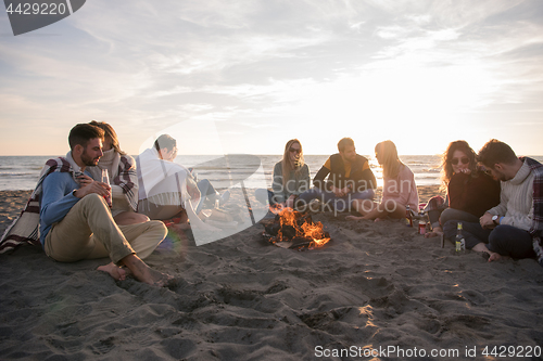 Image of Friends having fun at beach on autumn day