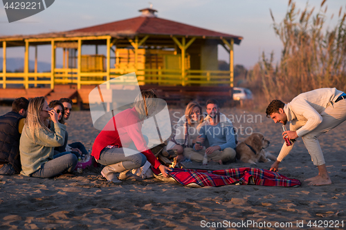 Image of Friends having fun at beach on autumn day