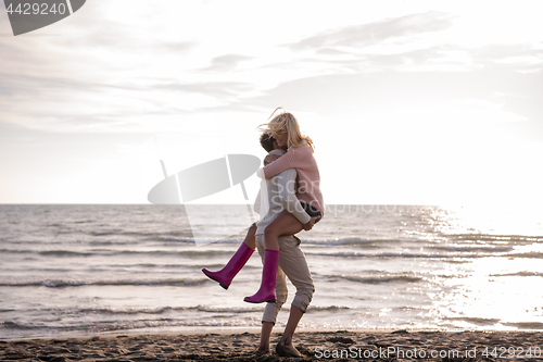 Image of Loving young couple on a beach at autumn sunny day