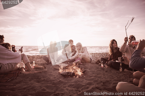 Image of Friends having fun at beach on autumn day