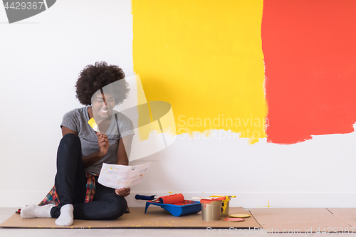 Image of back female painter sitting on floor