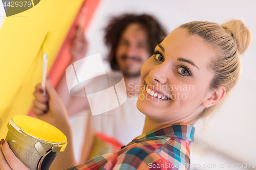 Image of couple painting interior wall