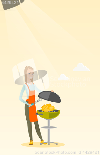 Image of Woman cooking chicken on barbecue grill.