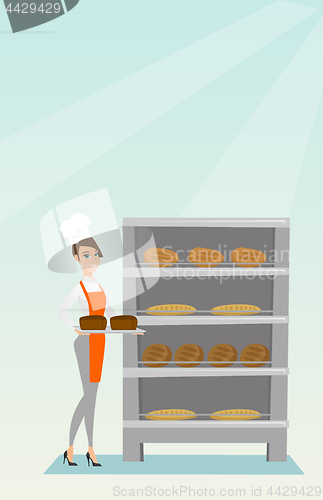 Image of Happy young baker holding a tray with bread.