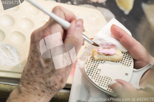 Image of Dental Technician Applying Porcelain To 3D Printed Implant Mold