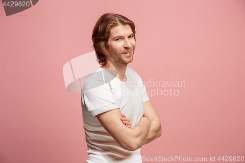 Image of The happy business man standing and smiling against pink background.
