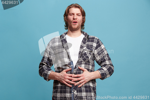 Image of The happy business man standing and smiling against blue background.