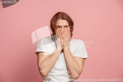 Image of The happy business man standing and smiling against pink background.