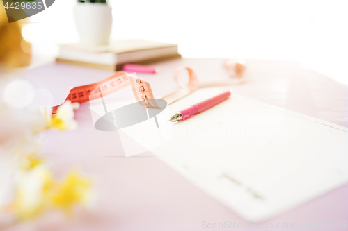Image of Notebook with pen, centimeter and paper on table