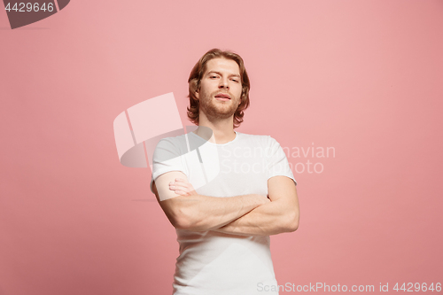 Image of The happy business man standing and smiling against pink background.