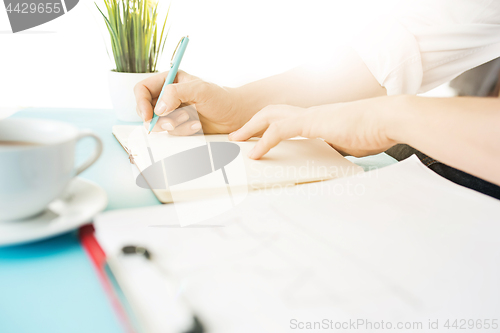 Image of The male hands holding pen. The trendy blue desk.