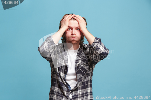 Image of Beautiful man looking suprised and bewildered isolated on blue