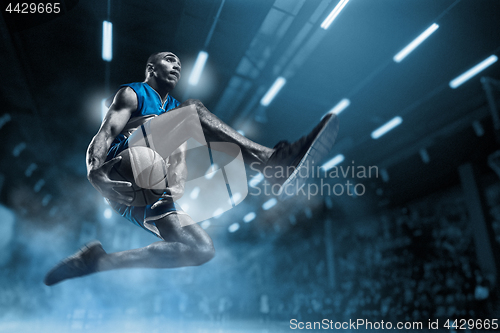 Image of Basketball player on big professional arena during the game. Basketball player making slam dunk.