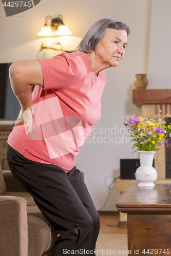 Image of Senior woman suffering from backache at home