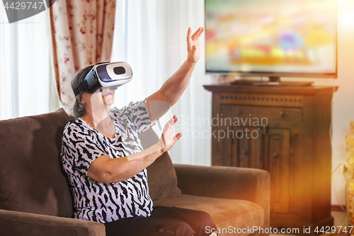 Image of Senior woman with virtual headset or 3d glasses playing