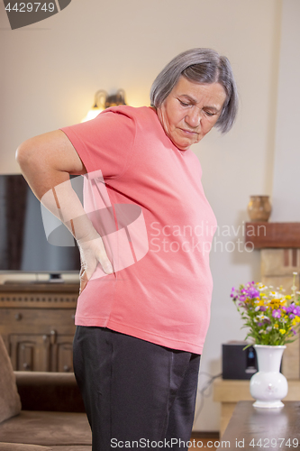 Image of Senior woman suffering from backache at home