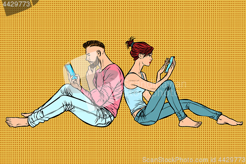 Image of Couple of man and woman sitting back to back and reading phone