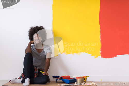 Image of back female painter sitting on floor