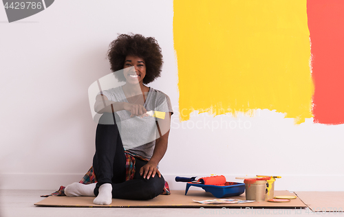 Image of back female painter sitting on floor