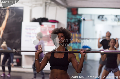 Image of black woman lifting empty bar