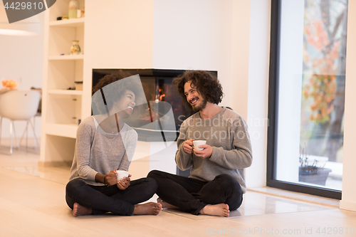 Image of multiethnic couple  in front of fireplace