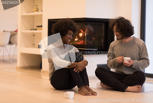 Image of multiethnic couple  in front of fireplace