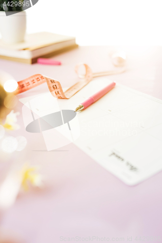 Image of Notebook with pen, centimeter and paper on table