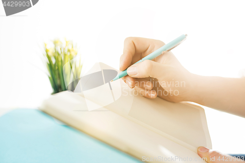 Image of The male hands holding pen. The trendy blue desk.