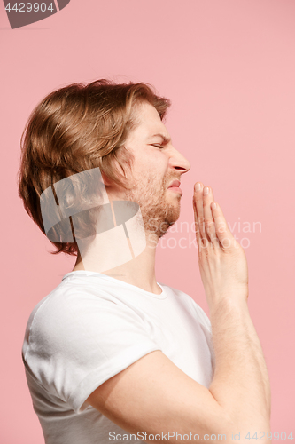 Image of Young man with disgusted expression repulsing something, isolated on the pink