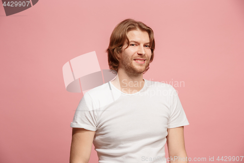 Image of The happy business man standing and smiling against pink background.