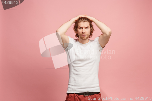 Image of Beautiful man looking suprised and bewildered isolated on pink