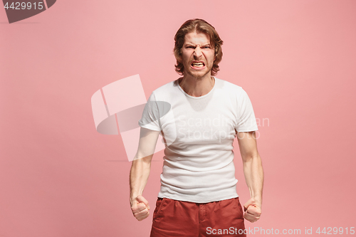 Image of The young emotional angry man screaming on pink studio background